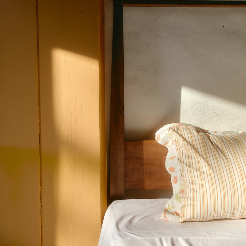 Bed with striped pillow in a softly lit room