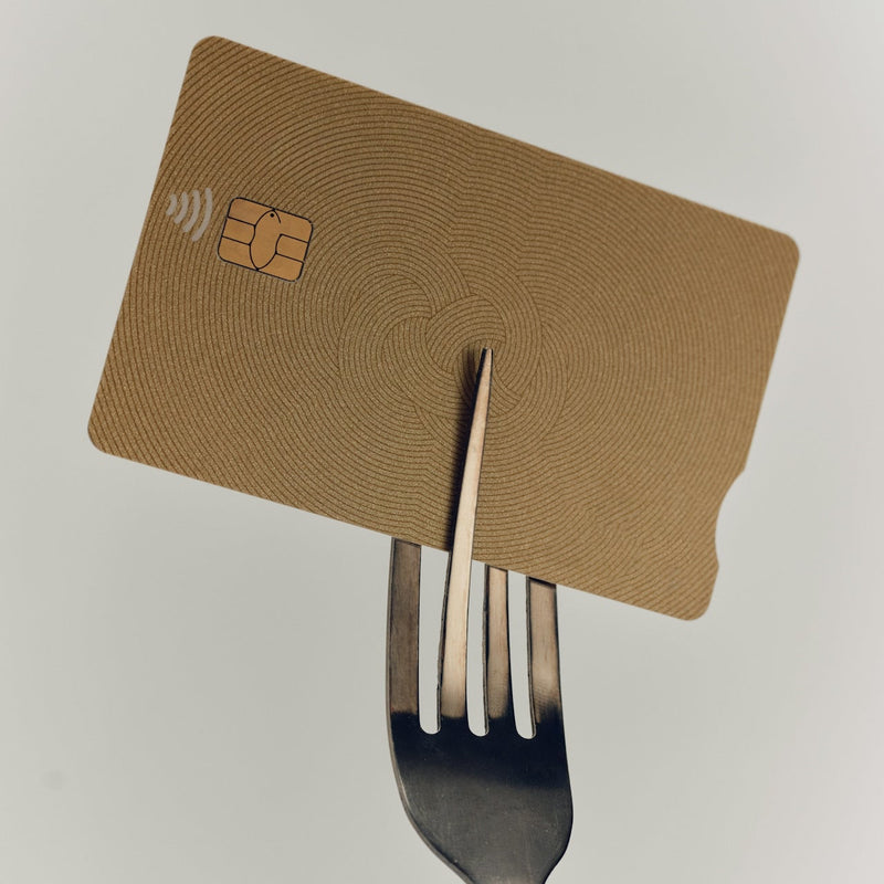 credit card with a fork on a light gray background