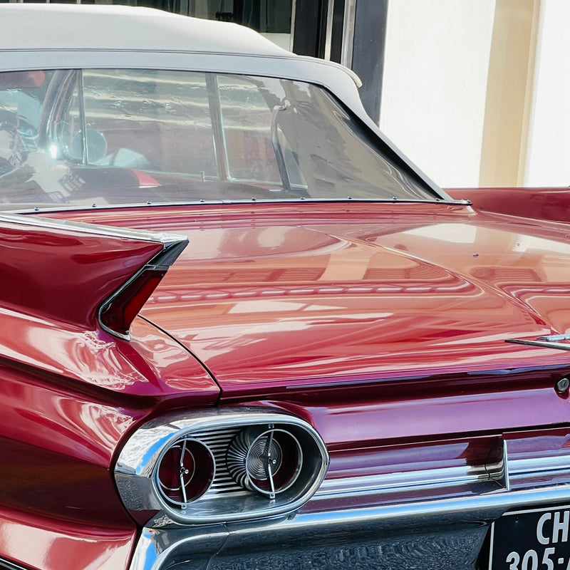 Close-up of a red old-timer car's rear end with visible license plate.